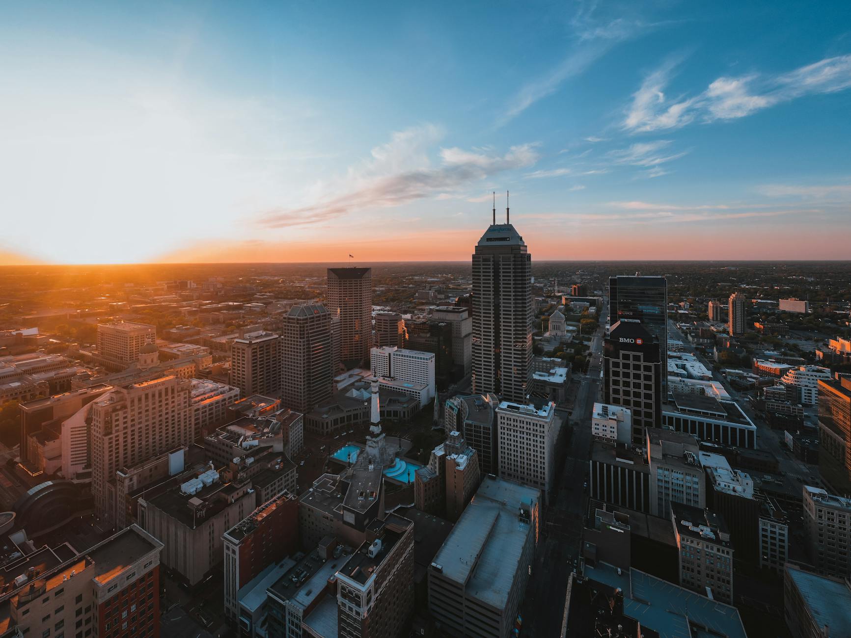 Breathtaking aerial view of Indianapolis skyline with dramatic sunset lighting up the cityscape.