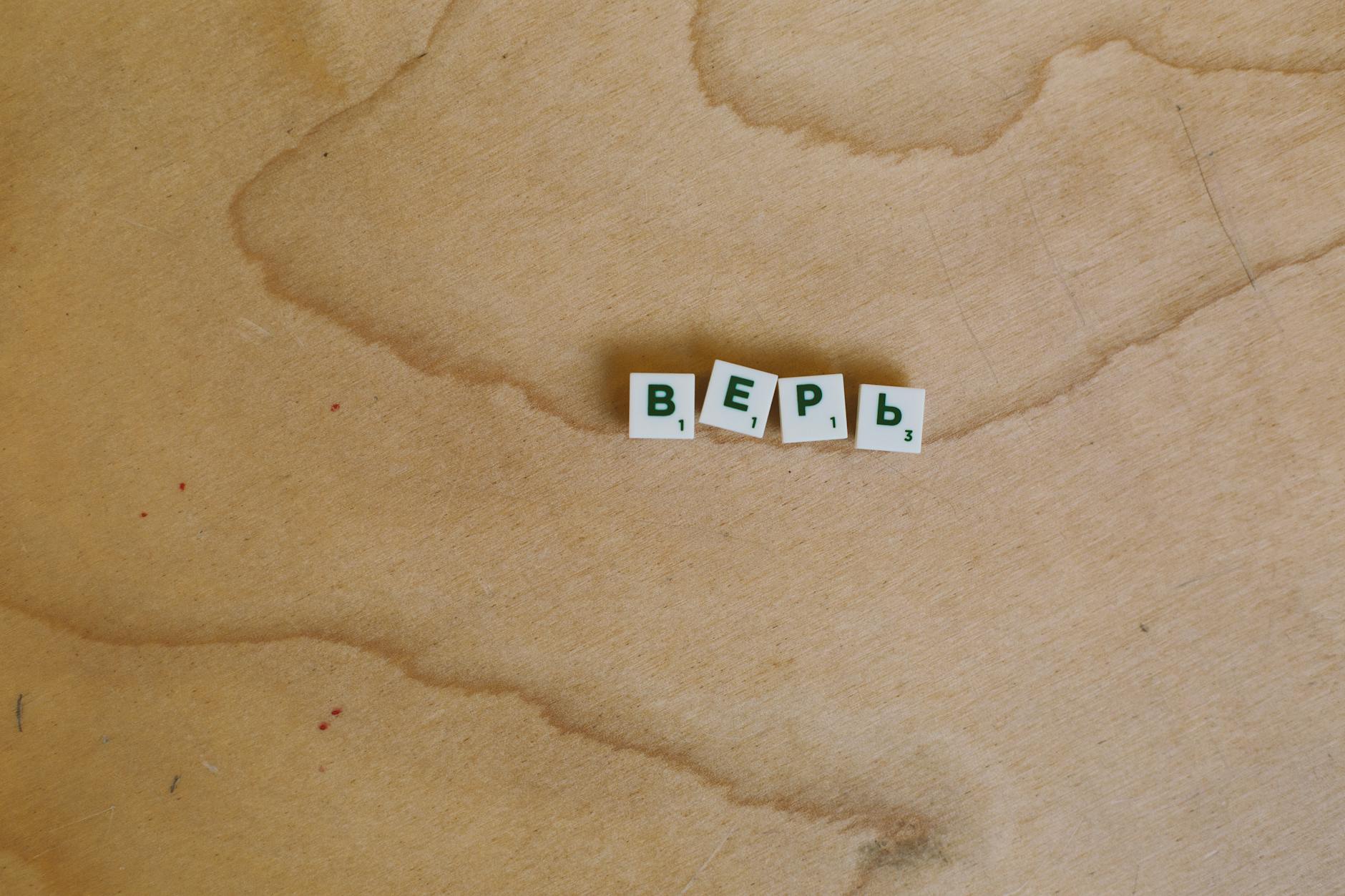 Scrabble tiles with Cyrillic letters spelling 'верь' displayed on a wooden surface.